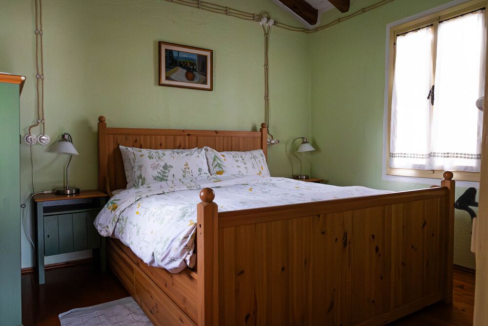 Camera verde con letto matrimoniale in legno